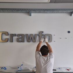 Montage der 3D-Logoelemente mit Edelstahlfronten bei Crawford in Düsseldorf
