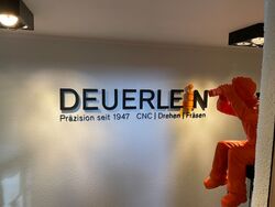 Fertiges 3D-Wandlogo der Dauerlein GmbH in Schwabach mit wechselbarem orangefarbenem Logo-Element