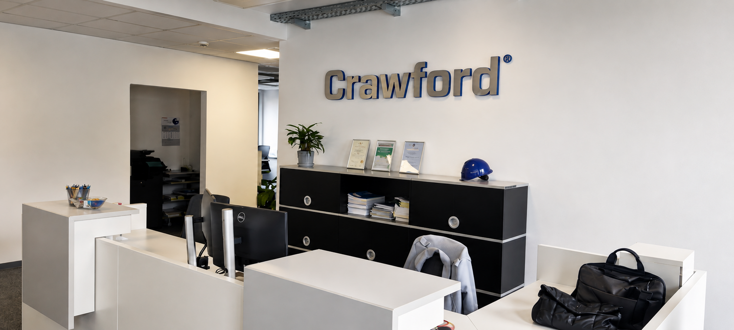 3D-Wandlogo von Crawford im modernen Empfangsbereich mit Empfangstheke und Firmenausstattung.